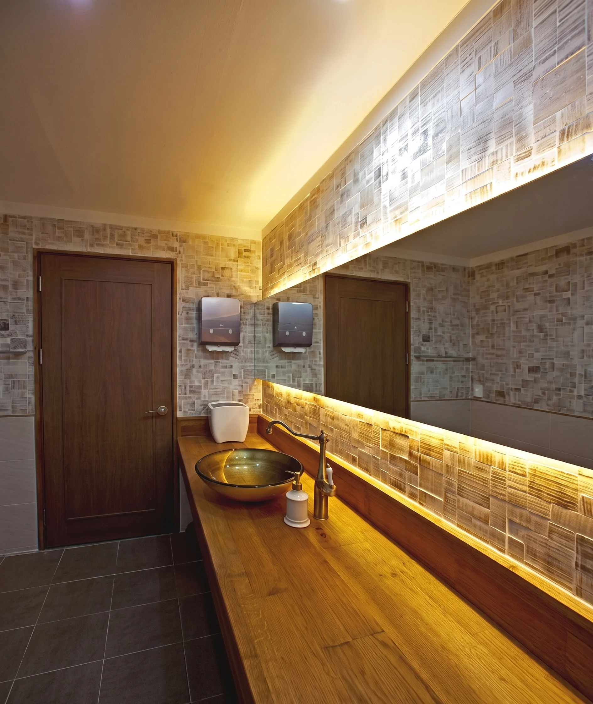 Bathroom with brick wall and wooden vanity countertop