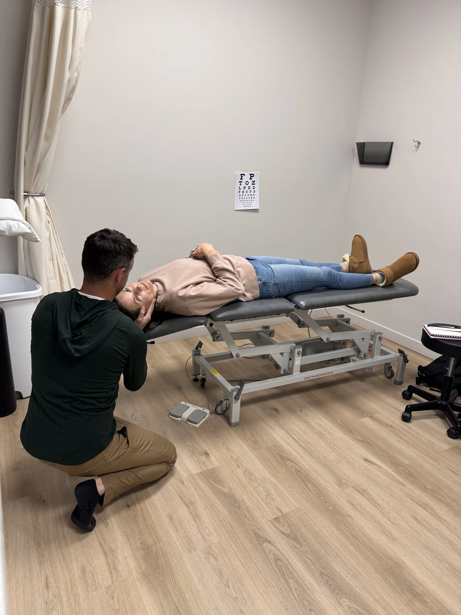 Clinician practising a supine assessment with a colleague