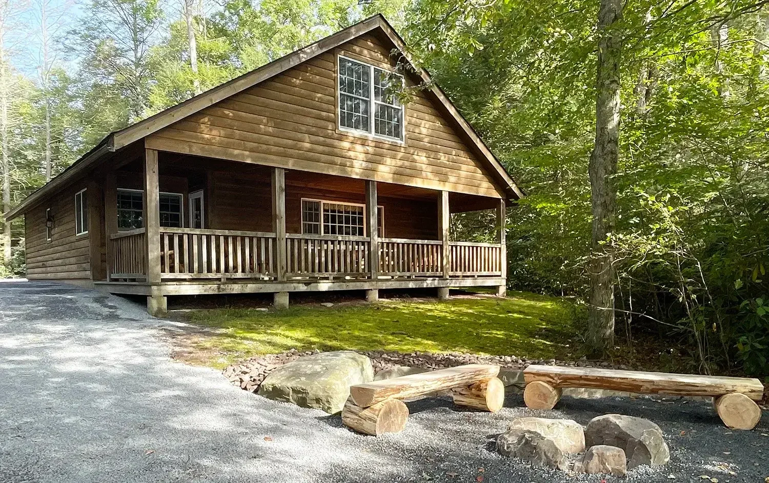 Hemlock Cabin 62 lakefront exterior with covered porch and fire pit at Mountain Springs Lake Resort