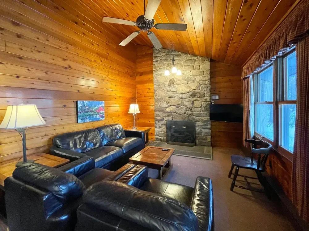 Cabin 39 living room with stone fireplace and leather seating