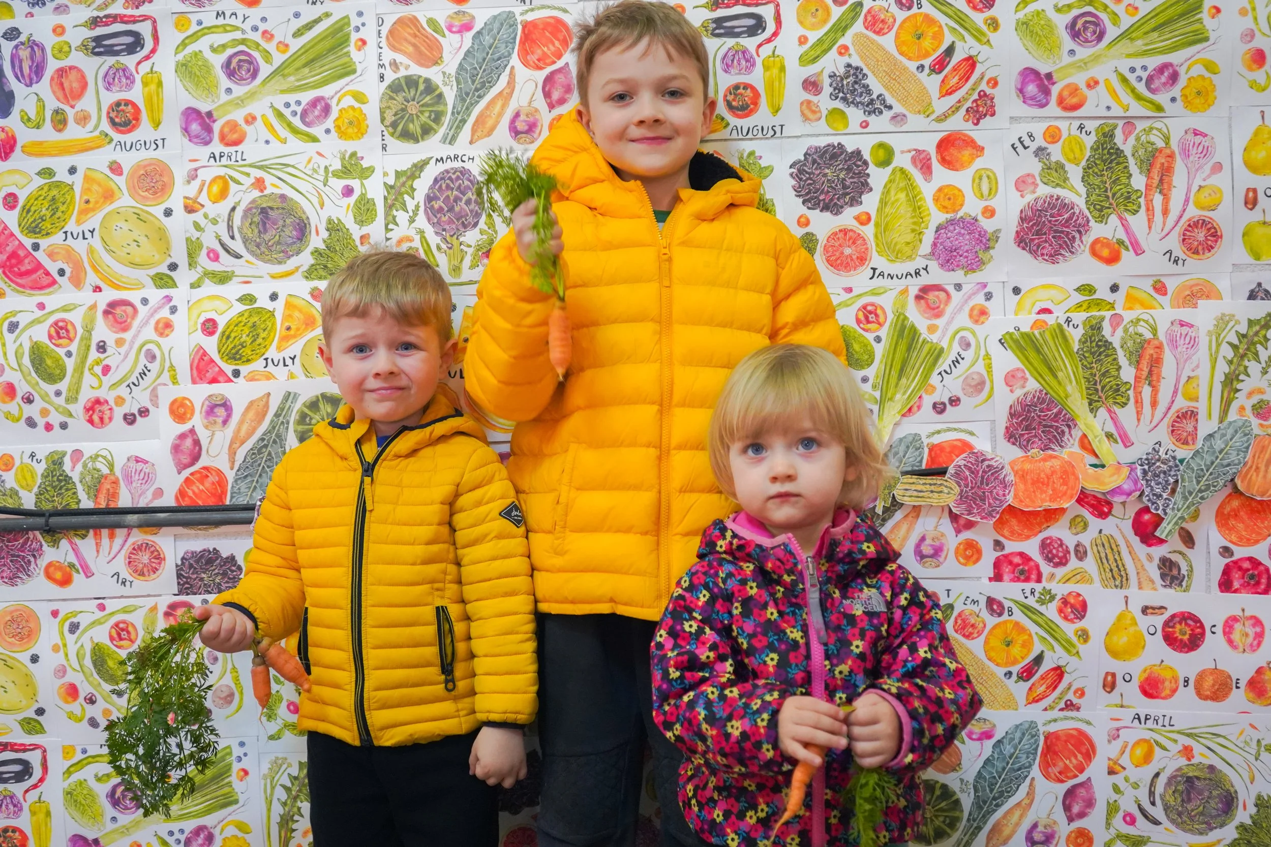 Kids on a farm tour with their hands raised in front of the SILO racks.