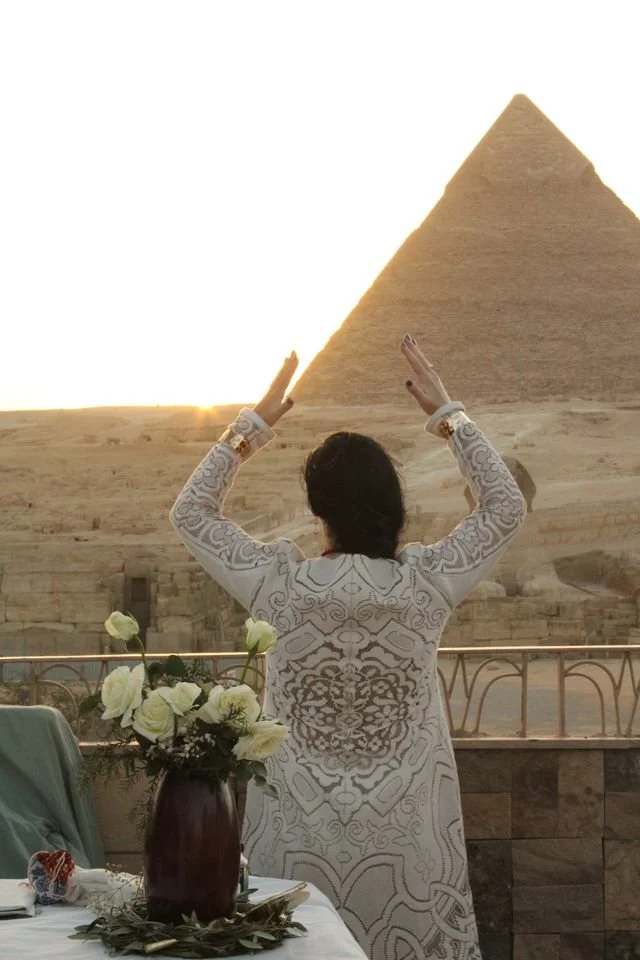 Participant raising her hands toward a pyramid