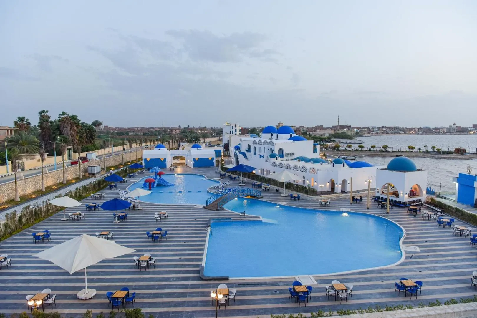 New Panorama Resort pools and white-and-blue buildings beside the water in Fayoum