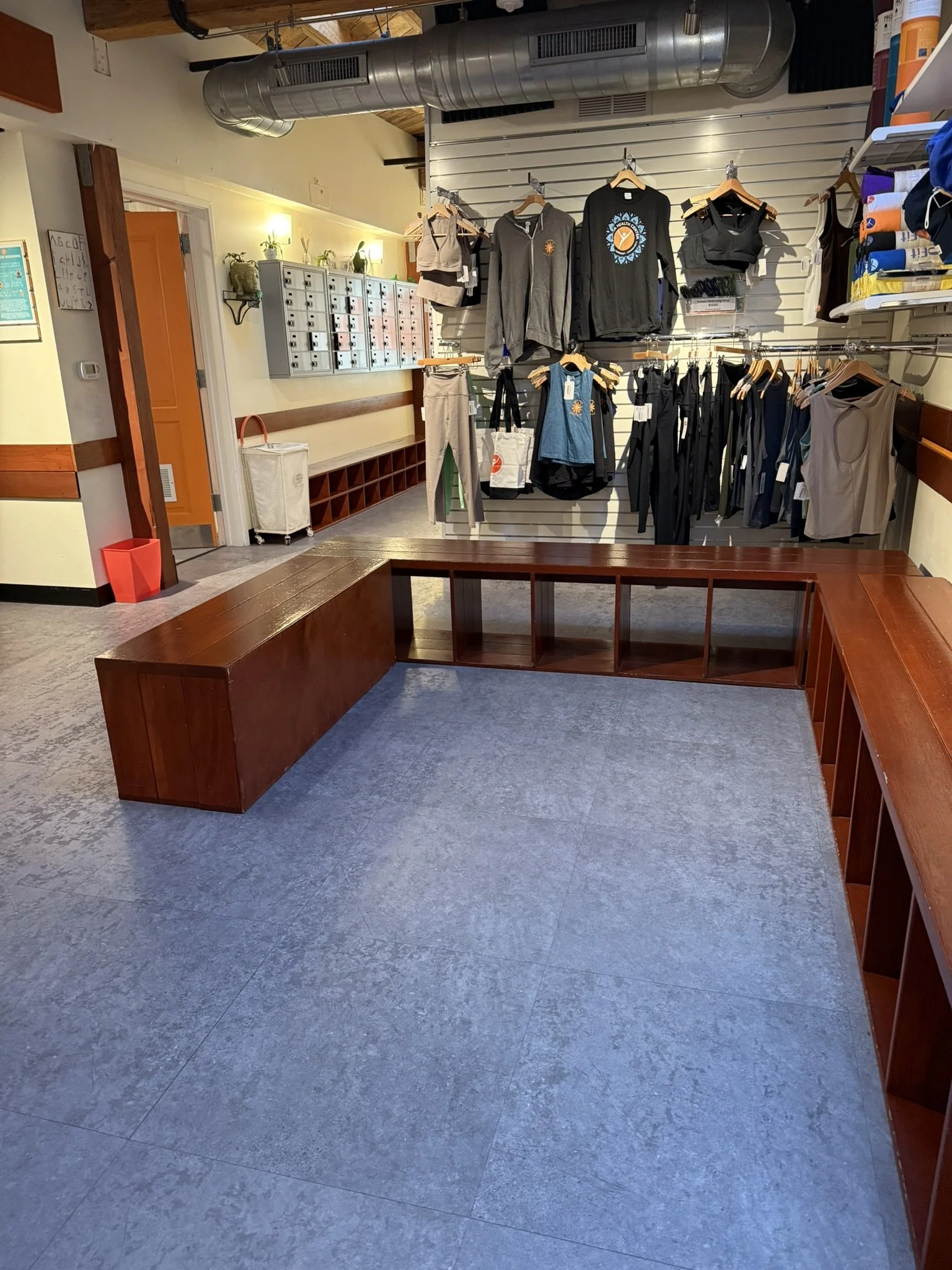 U-shaped redwood bench seating with the boutique behind it at Yoga Health Center
