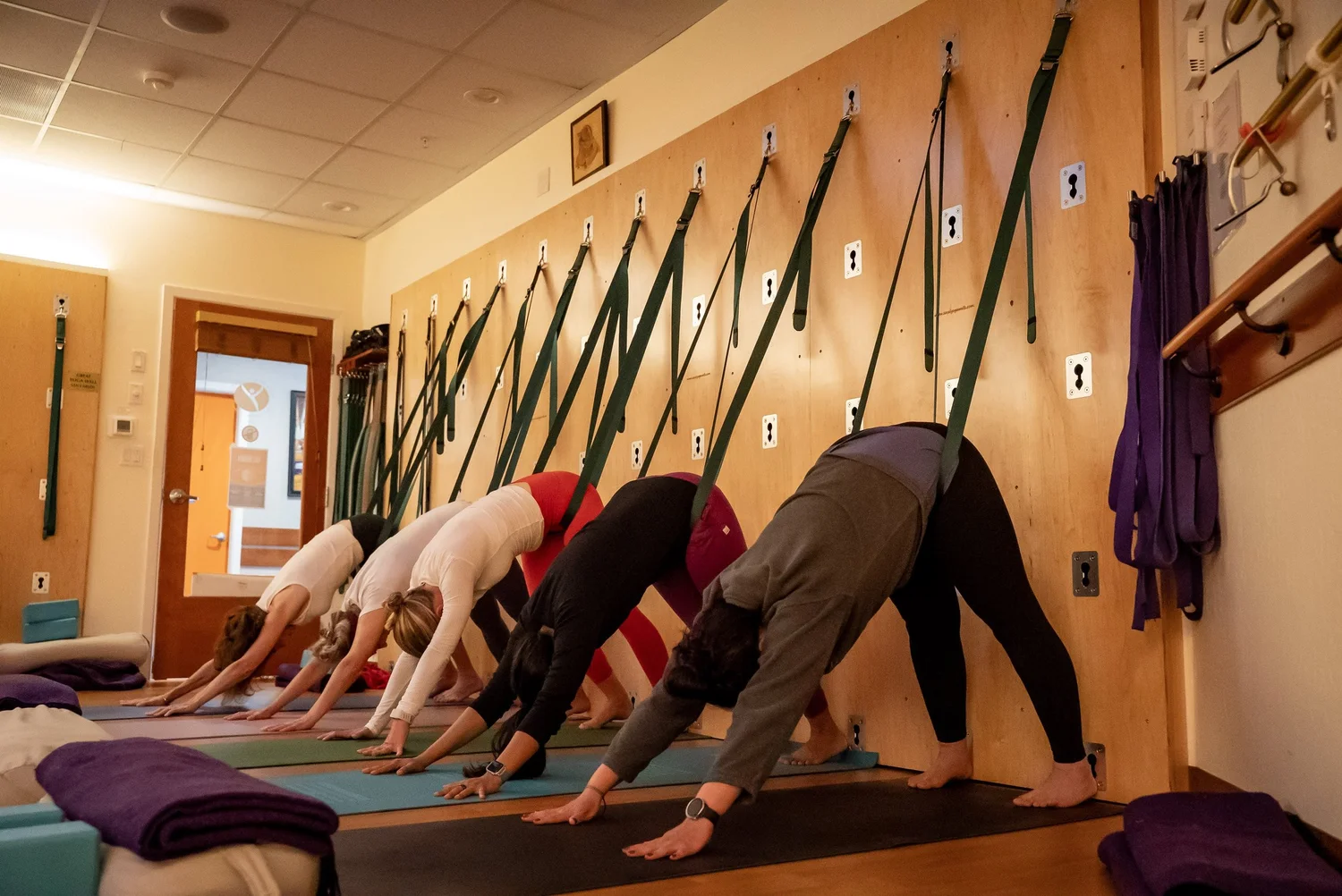 Students in downward dog on the rope wall