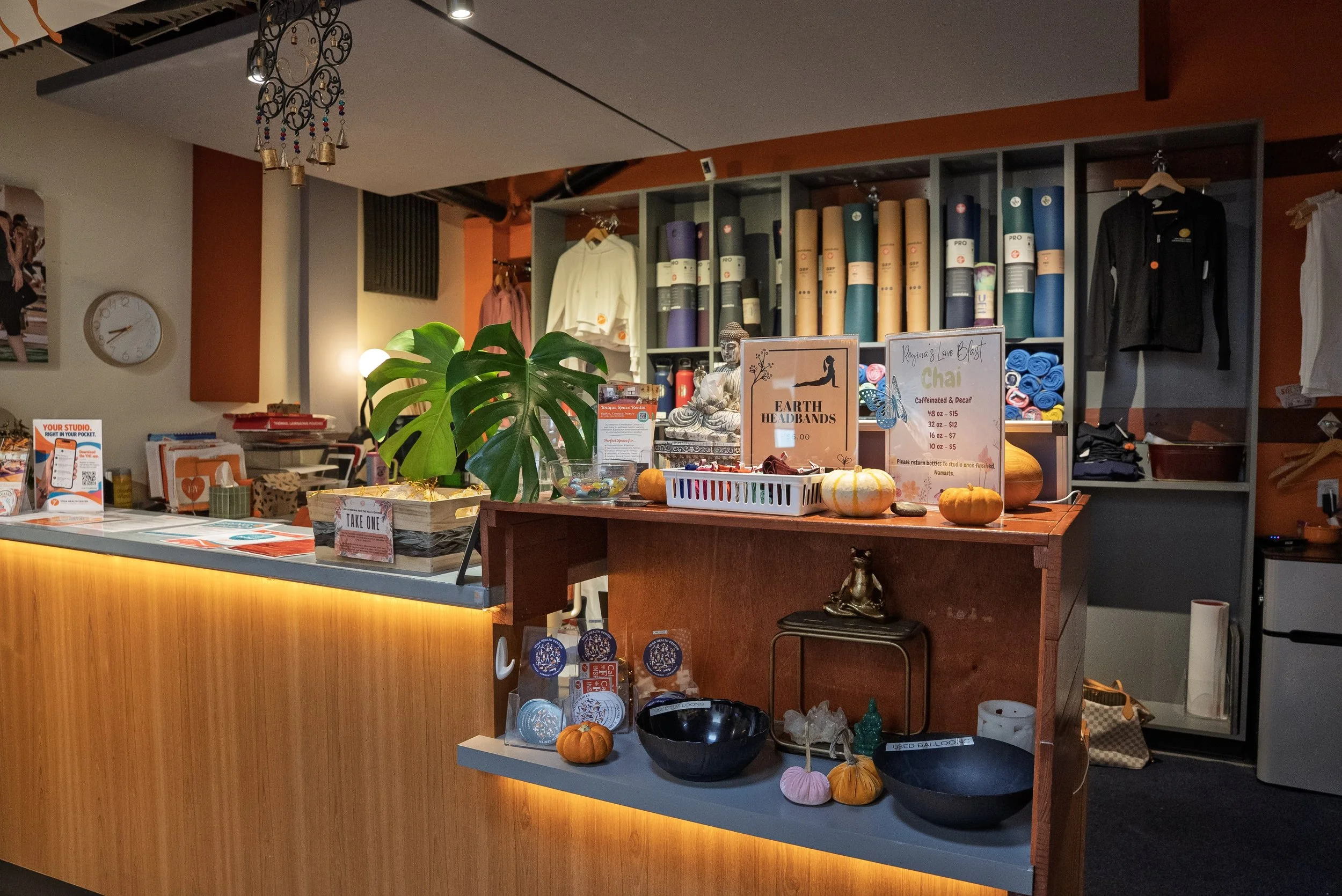 Warmly lit front desk with the boutique behind it at Yoga Health Center