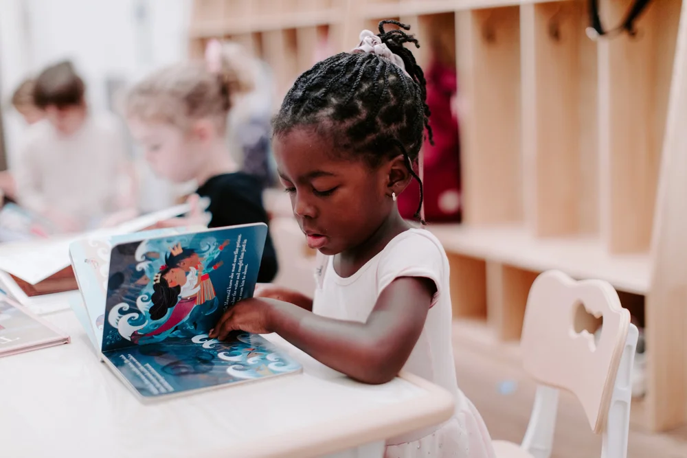 A young dancer looking at a picture book