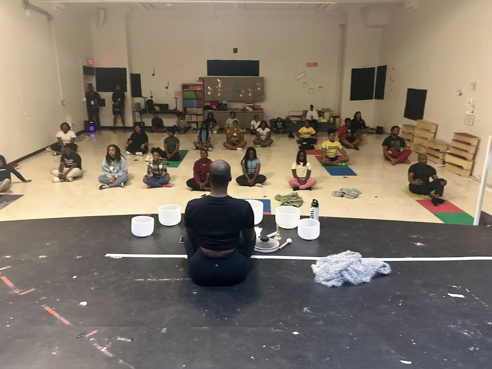 Students seated cross-legged for a wellness and sound-bowl session