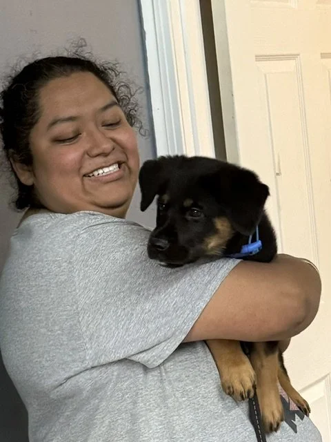 A woman holding a puppy