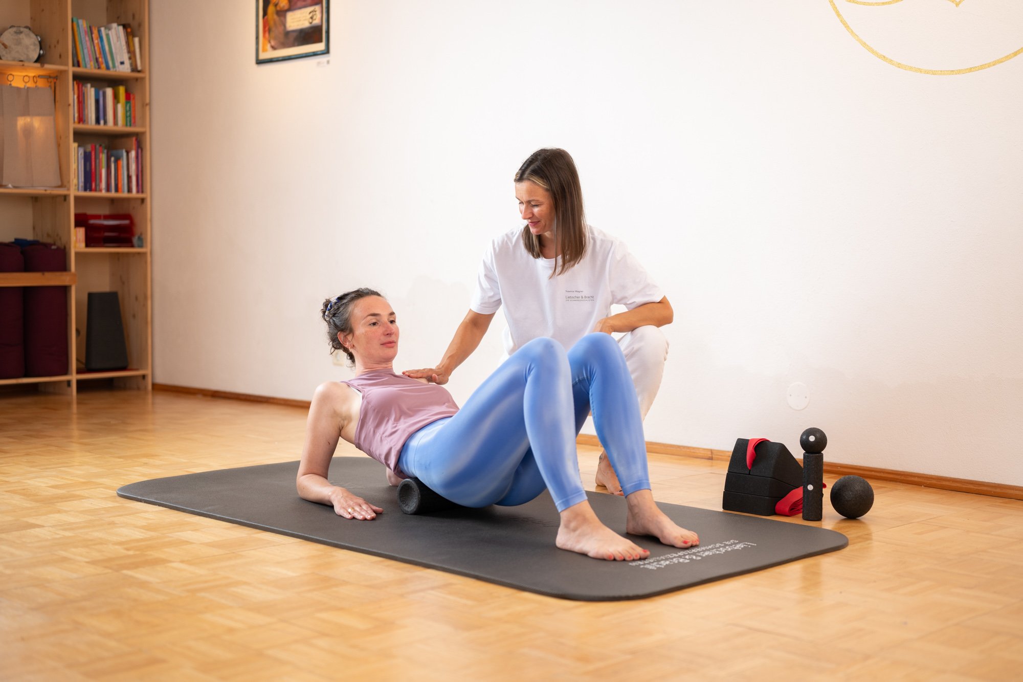 Angeleitete Faszien-Rollmassage mit einer Rolle auf der Matte.