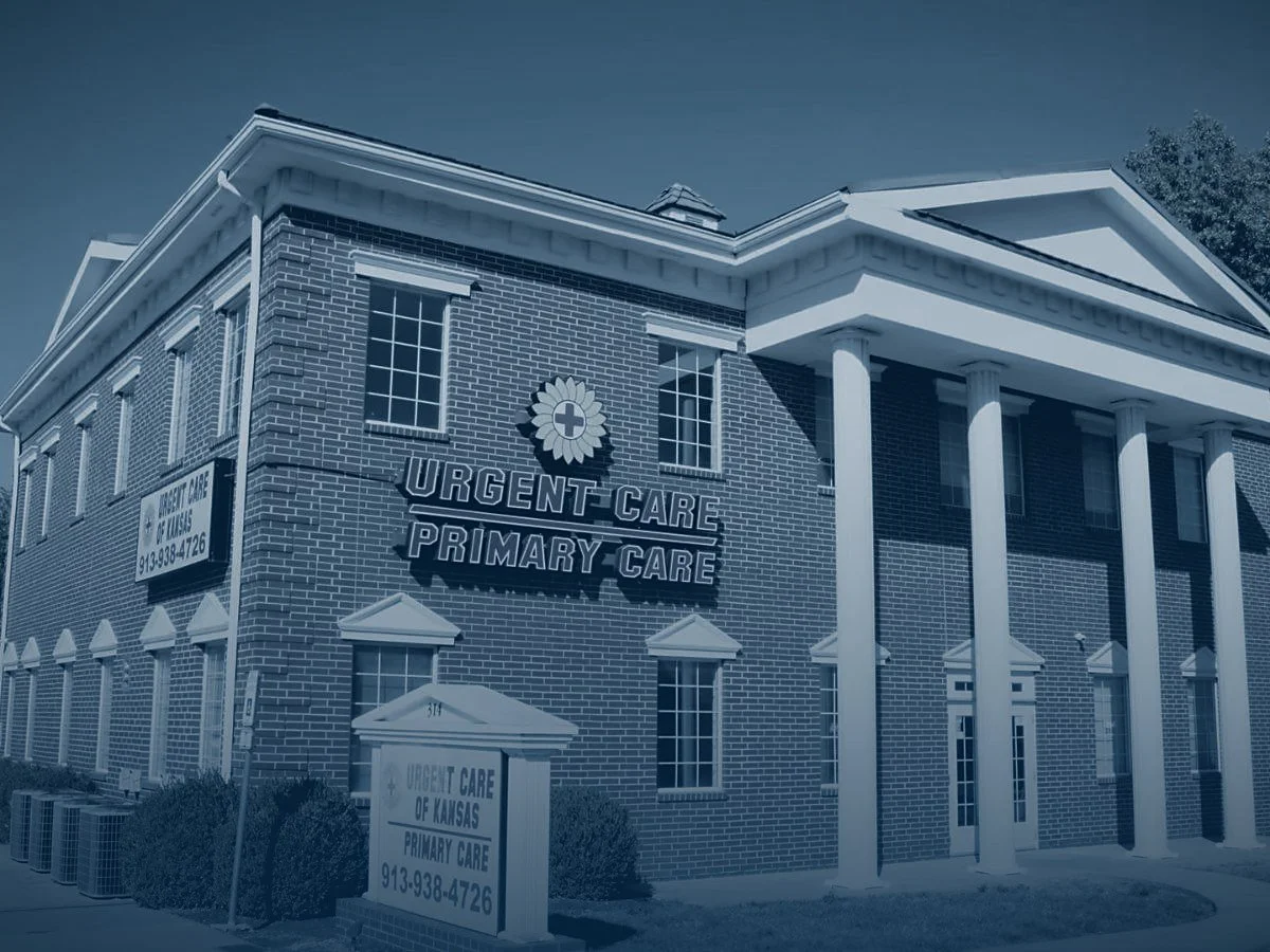 The Urgent Care of Kansas building in Gardner — red brick with white columns and Urgent Care and Primary Care signage.