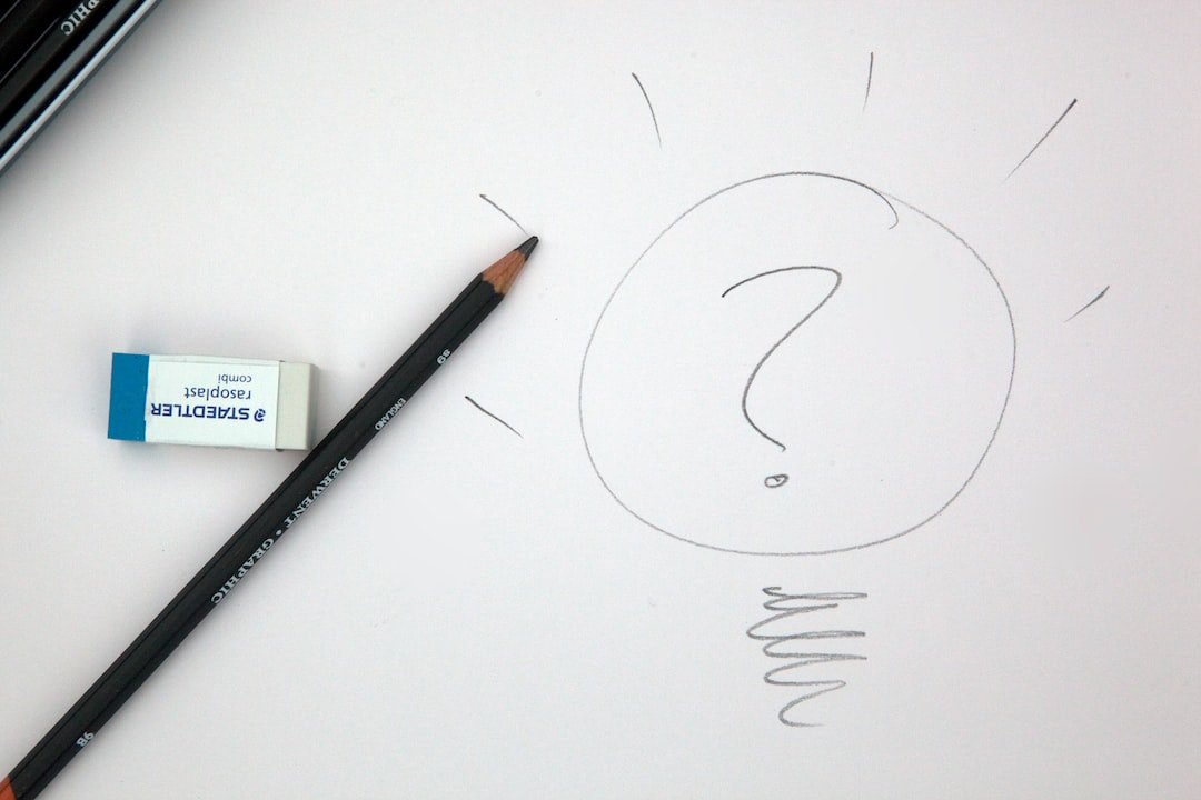 pencil and peice of paper with a lightbulb and question mark