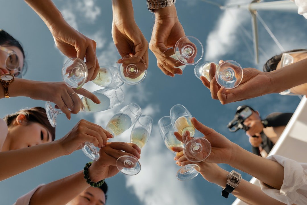 Glasses raised against a blue sky