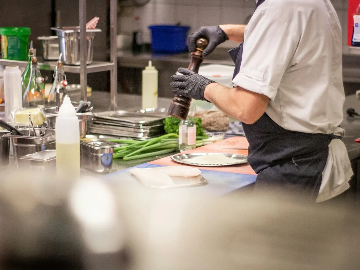 A chef finishing a plate in a restaurant kitchen
