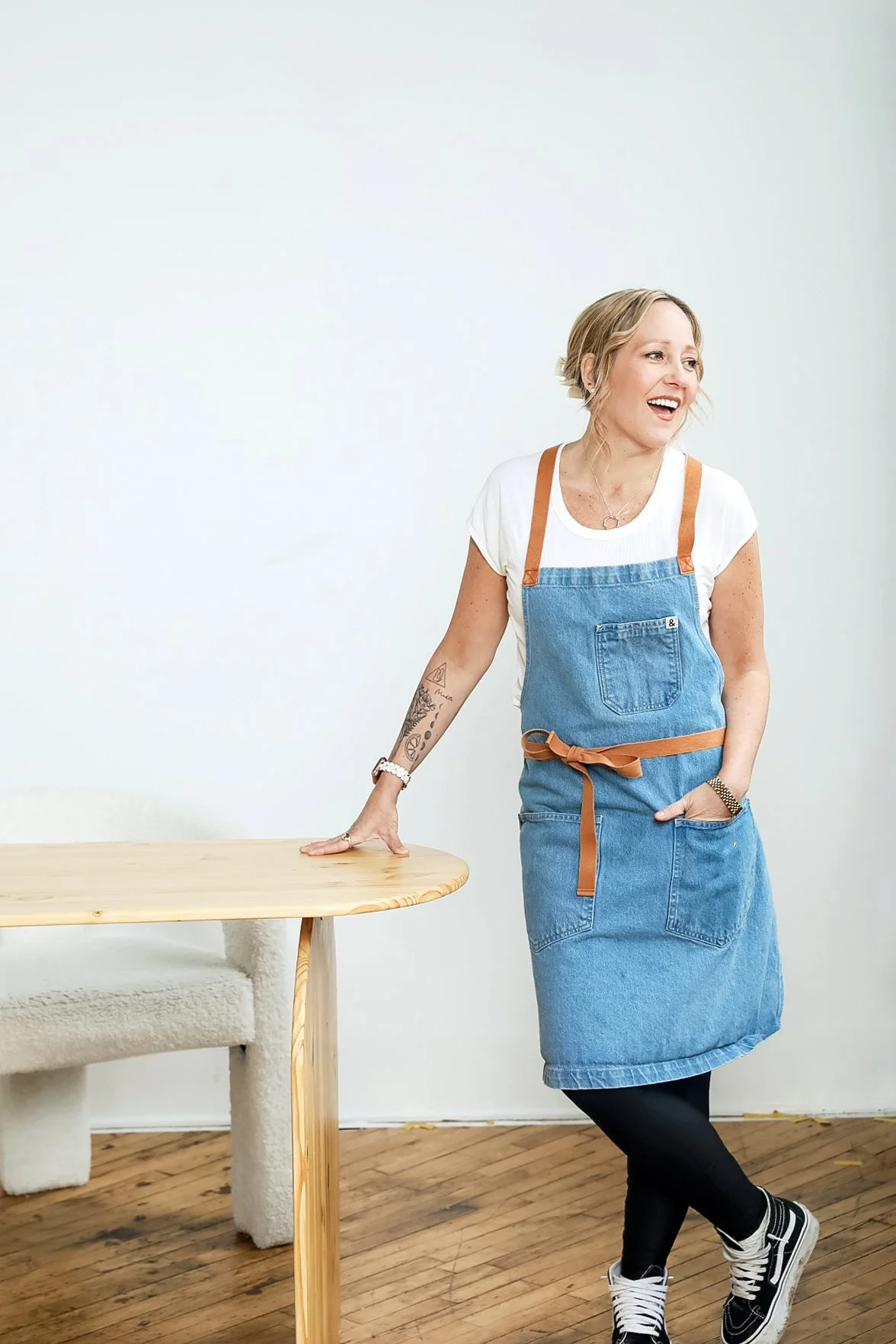 Chef Katie Barnes of Porch Light Gatherings wearing a blue apron