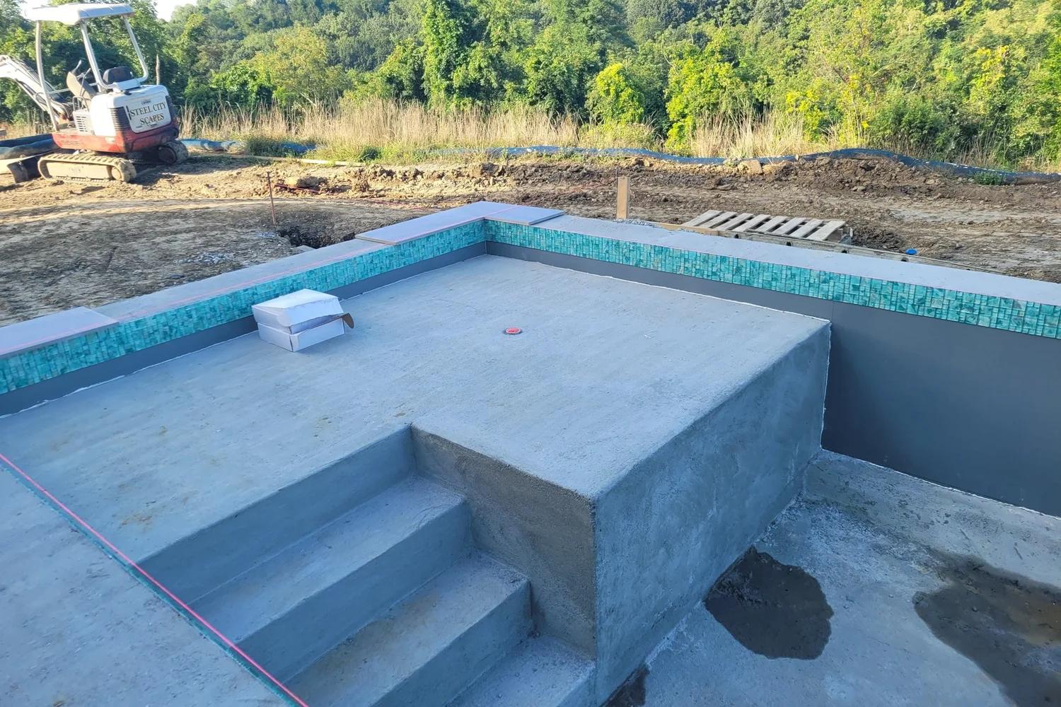 The pool steps and tile line finished, with the deck still to come