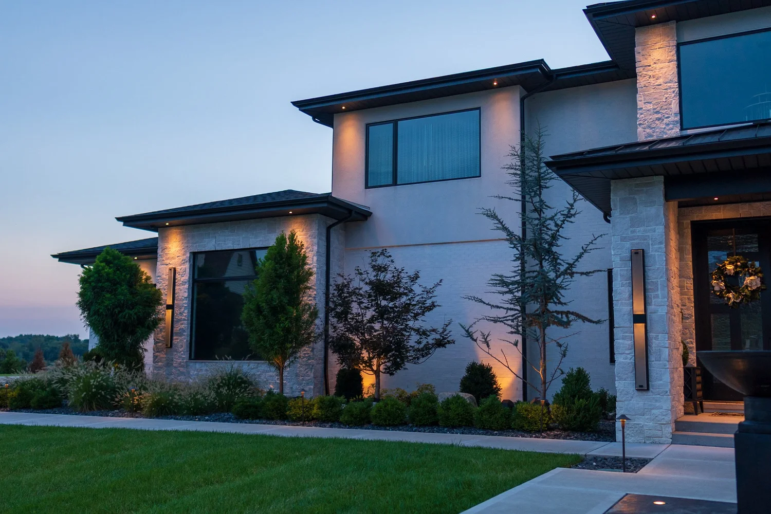 The front of the house, planted and lit at dusk