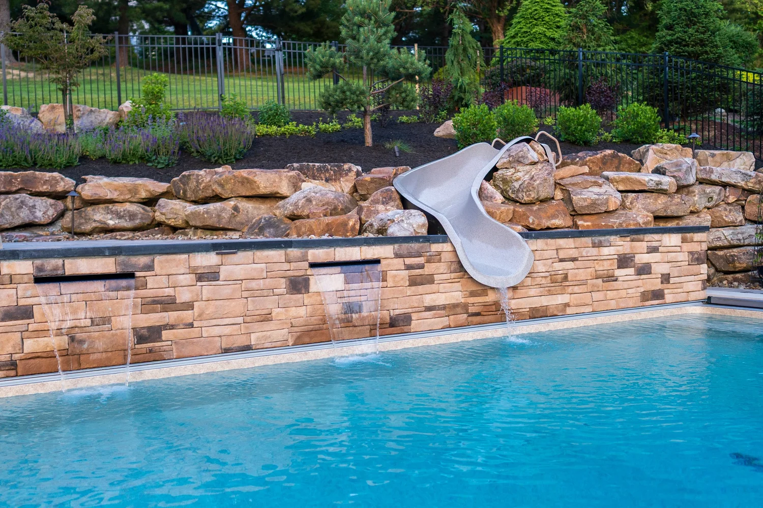 The raised wall with its three scuppers and the slide, above the pool
