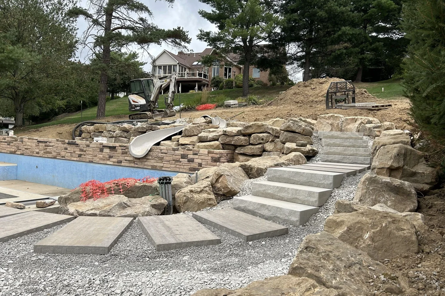 Stone steps laid through the boulders beside the pool