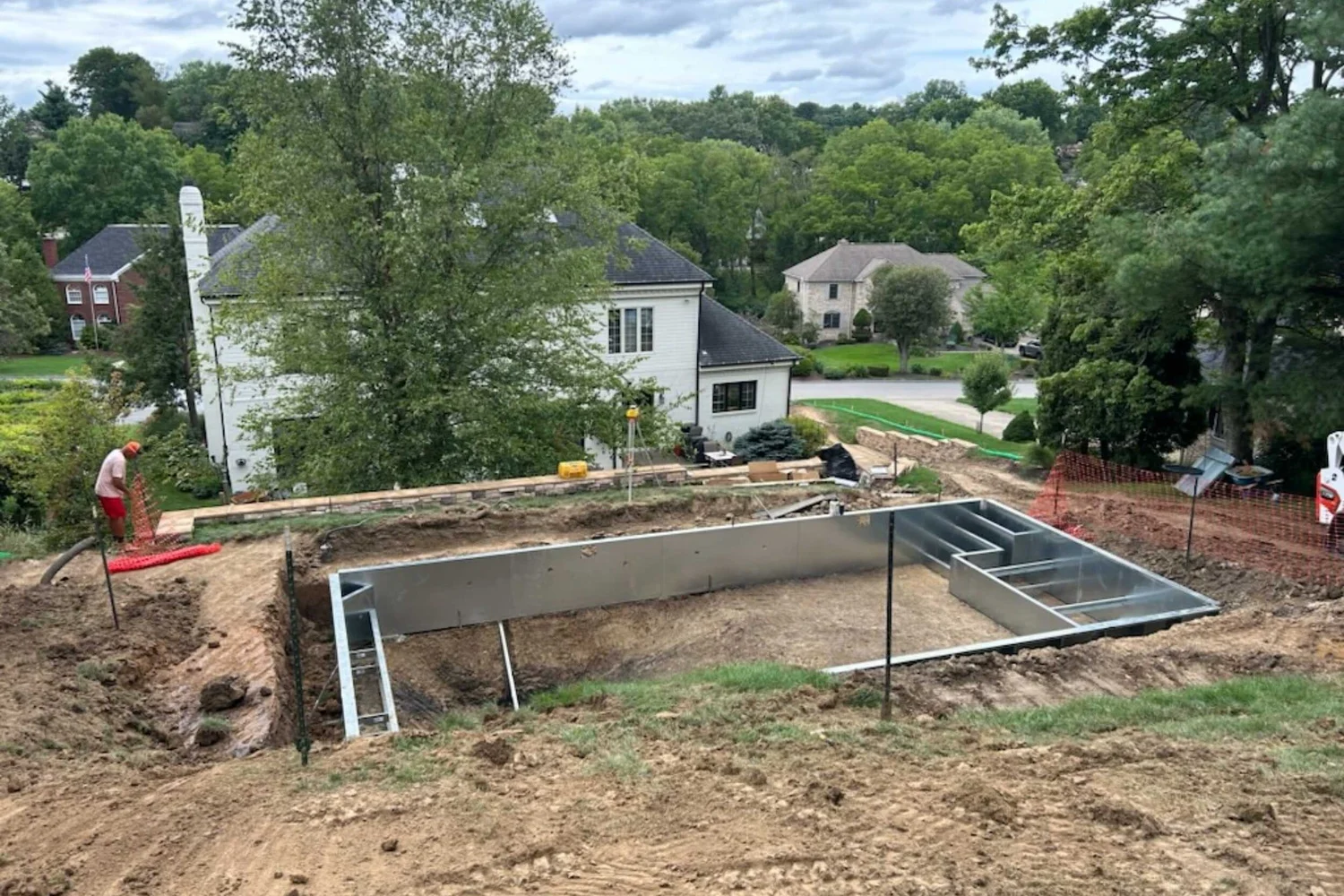 The steel pool walls set in the dig, with the house below