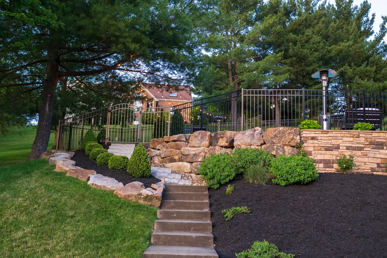 Stone steps climbing from the lawn to the pool terrace