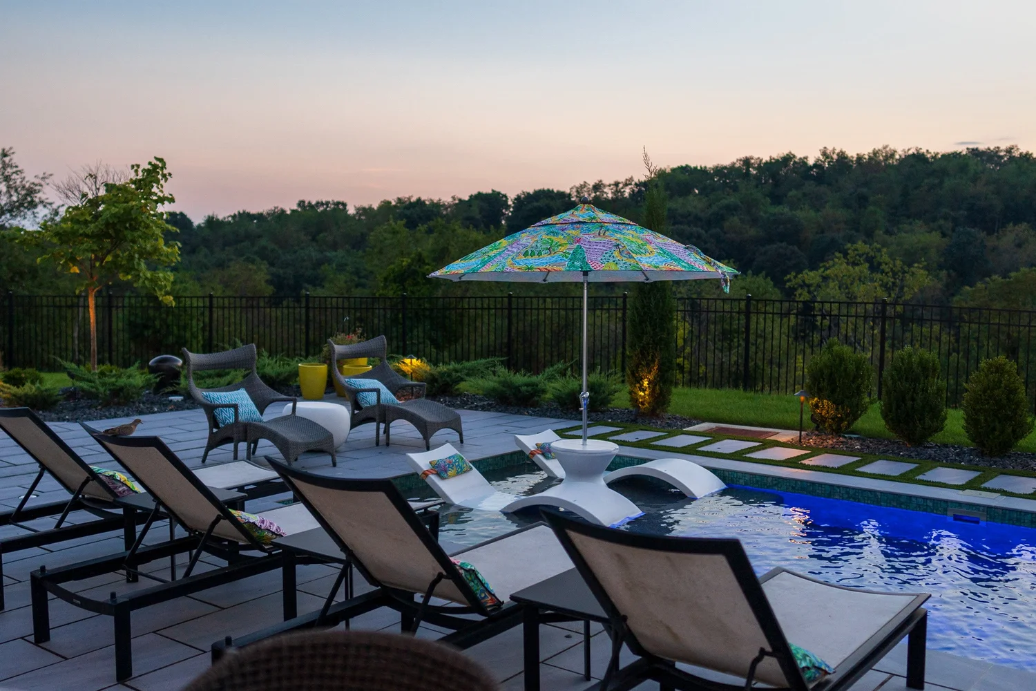 Loungers on the deck facing the pool and the view