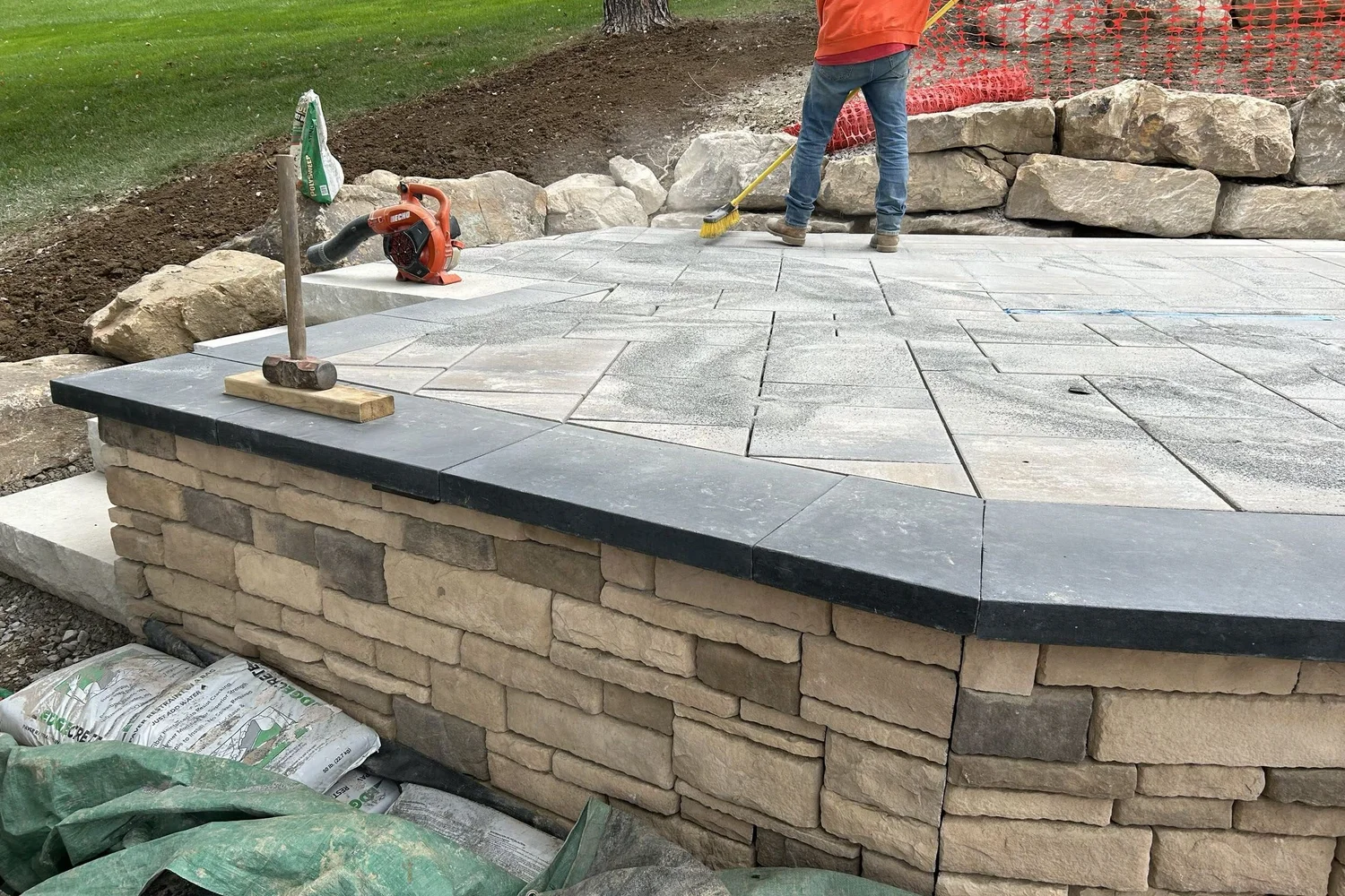 Pavers going down on the terrace above the stone wall