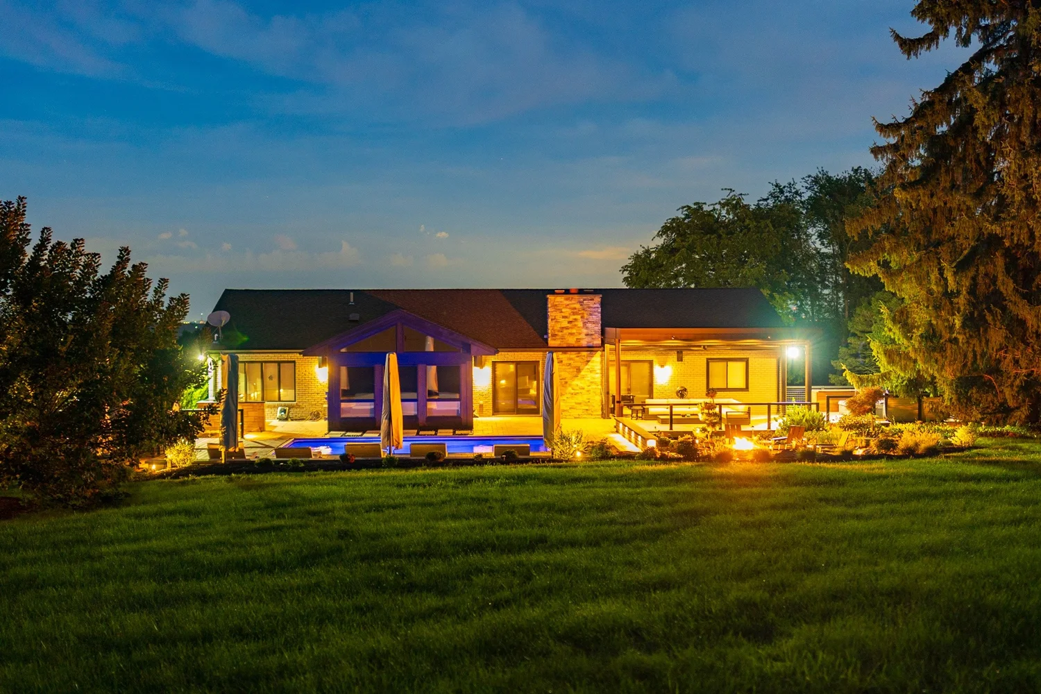The house and yard at dusk from the far end of the lawn