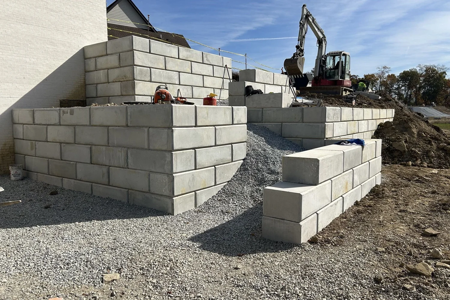Large wall blocks of the retaining walls stepping up beside the house