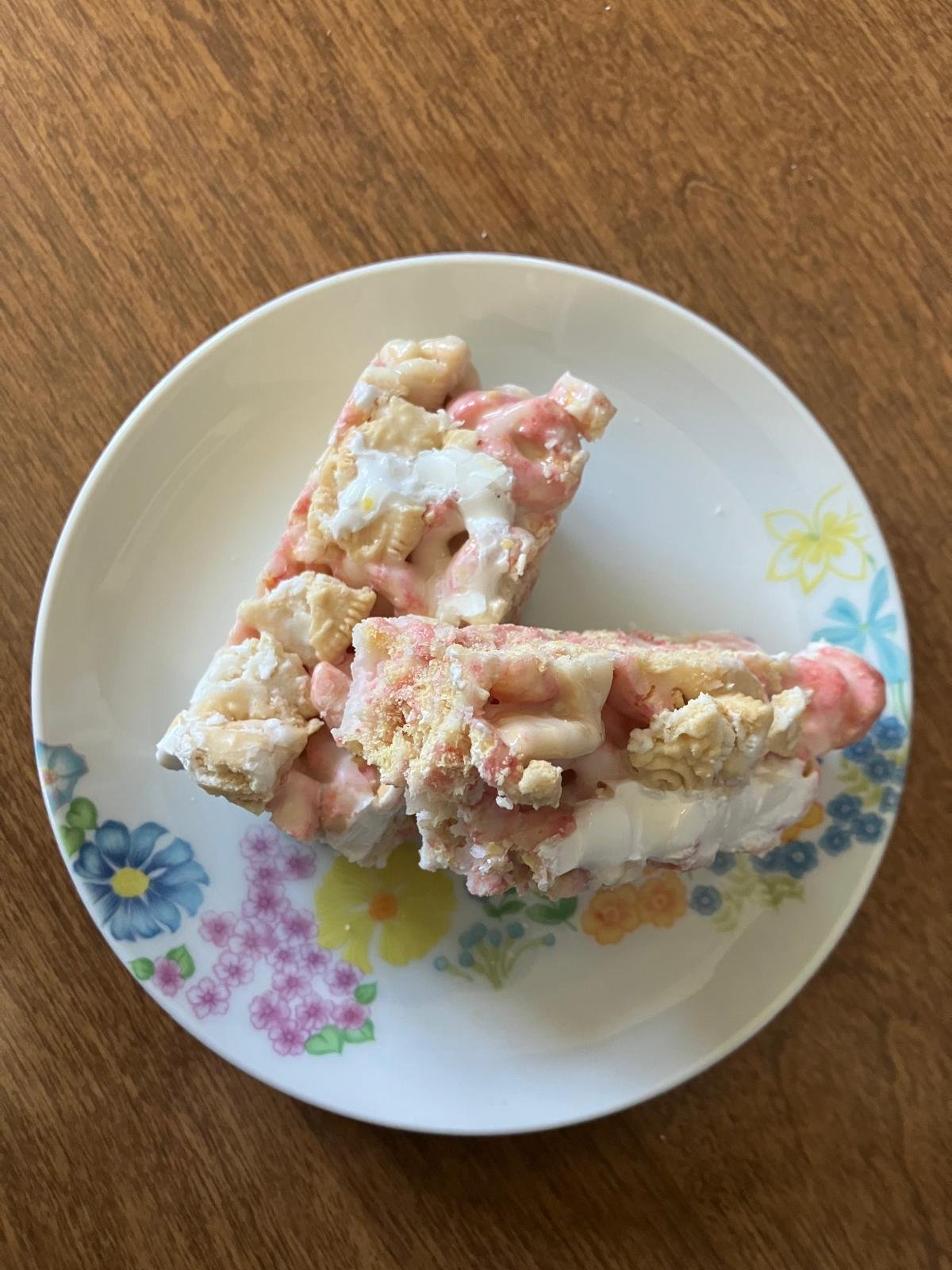 Top view of two pink cereal bars stacked on a white plate