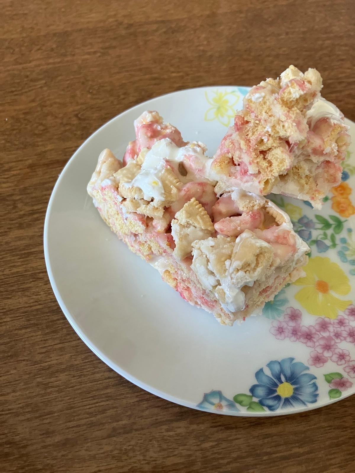 Two pink gluten-free cereal treats stacked on a plate