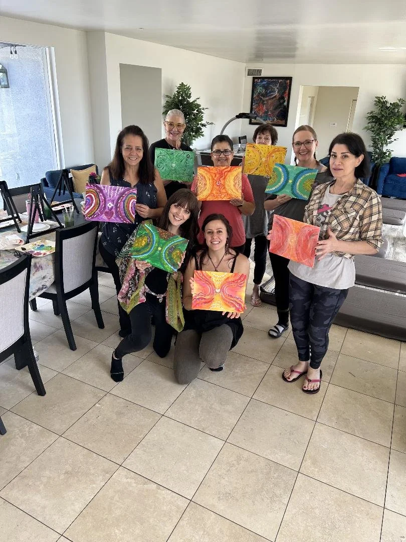 Happy painters holding up their colorful artwork