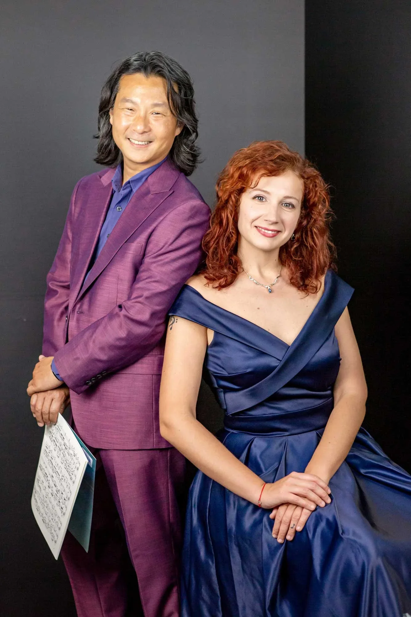 Mada & Hugh Piano Duo — Hugh in a purple suit, Madalina in a blue gown