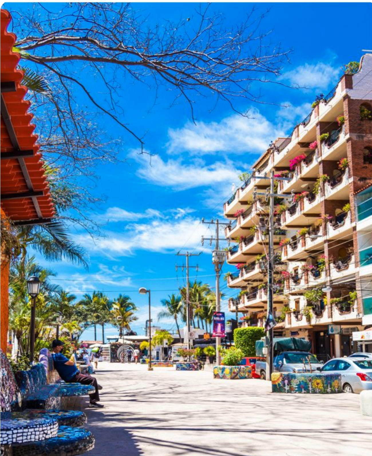 A sunny plaza in the Zona Romántica, Puerto Vallarta, with mosaic-tiled benches, palms and balconies draped in bougainvillea