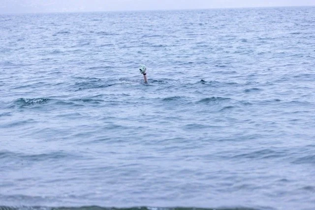 Nearly submerged in cold Puget Sound — green beanie above the waves, Vashon Island