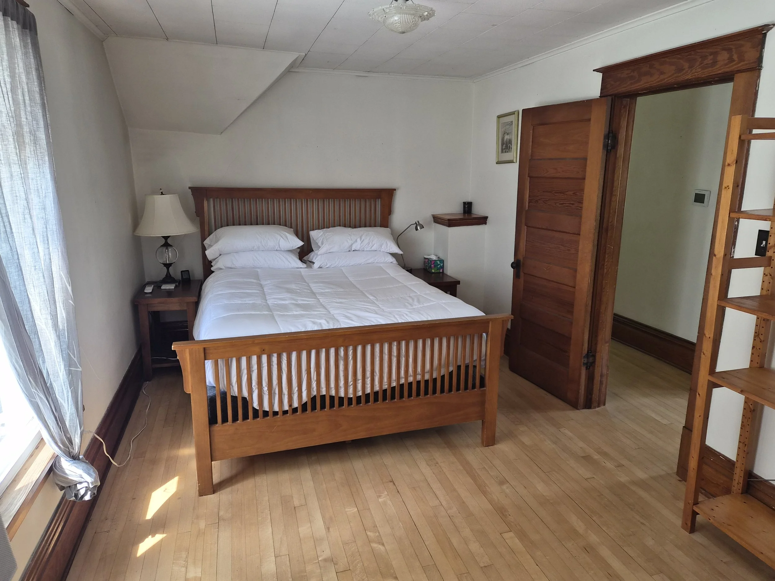 Queen bedroom at The Angel's Share with hardwood floors and original woodwork