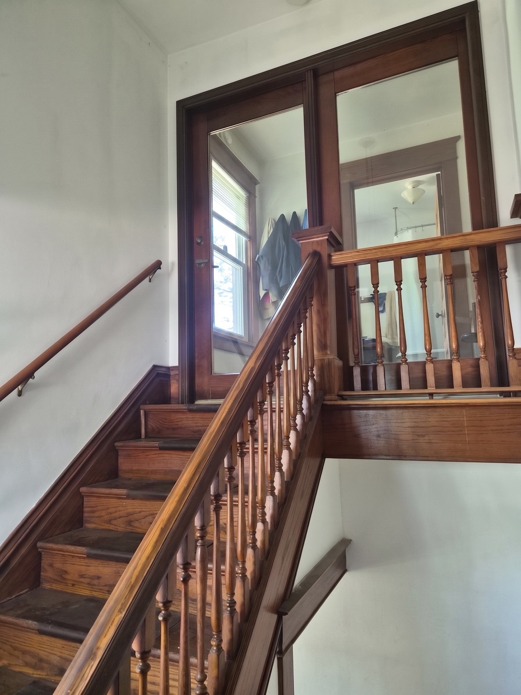 Historic wooden stairway leading to the second-floor apartment