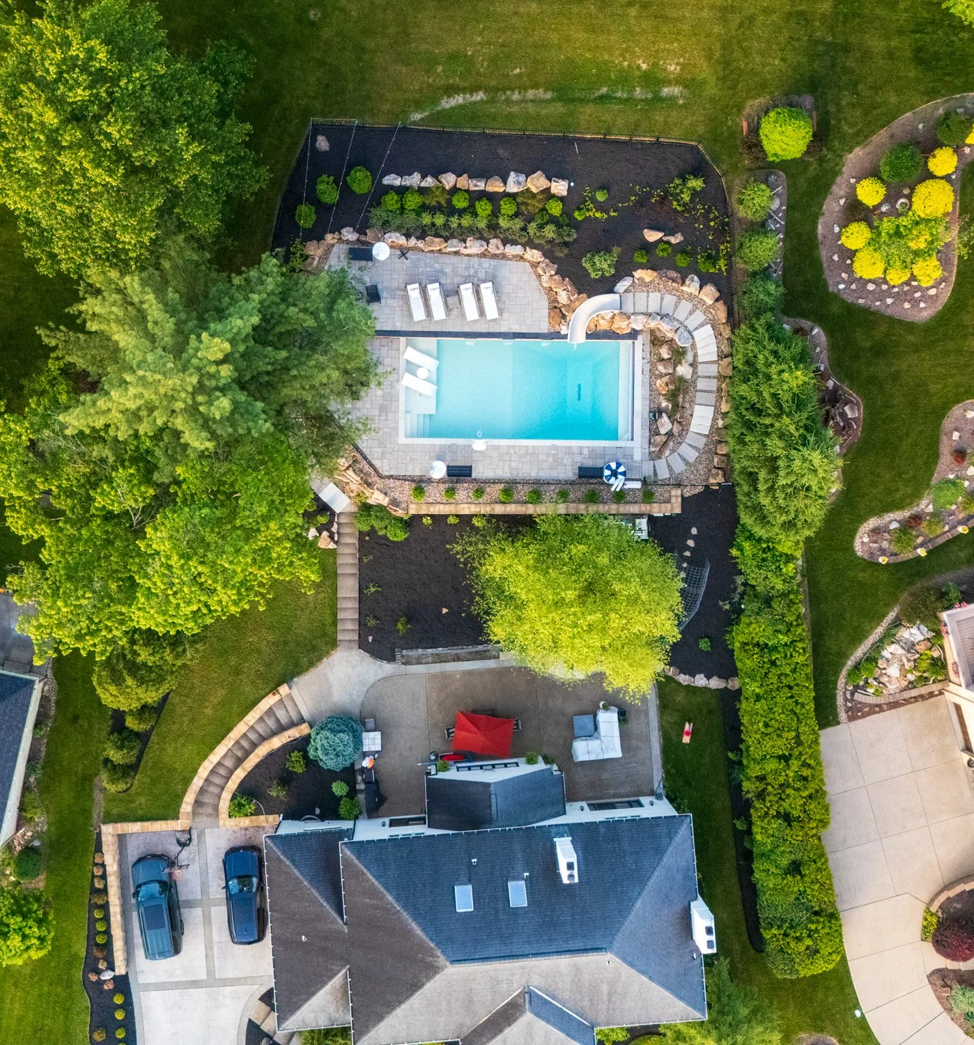 Finished pool terrace on a sloped backyard, seen from above with the house and the original patio