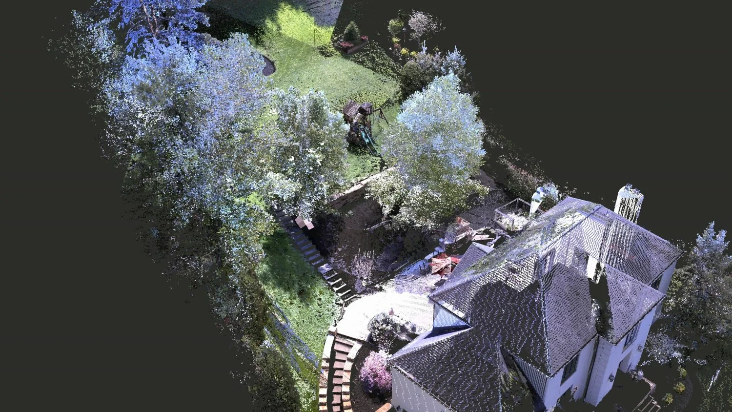 A colored 3D point cloud of a house, patio and sloped yard