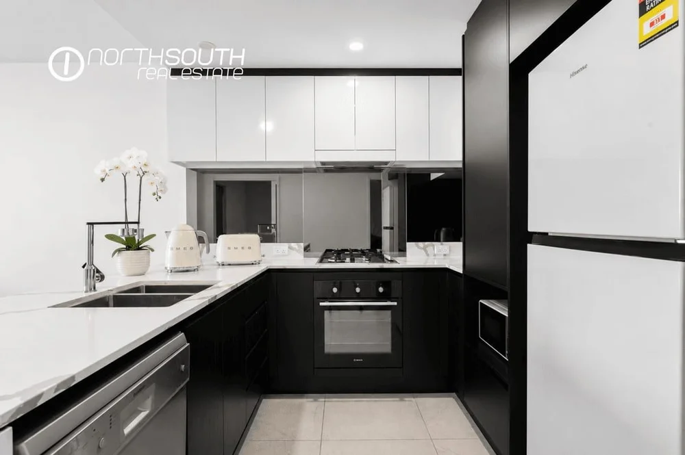 Kitchen with stone benchtops and gas cooktop in apartment 5608, Waterpoint Residences