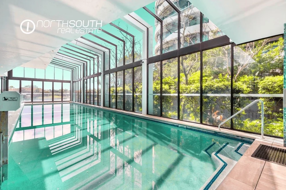 Indoor lap pool under a glass roof at Waterpoint Residences