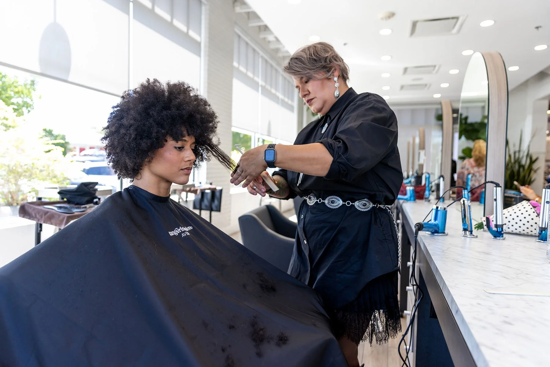 Curly hair client at Tangerine Salon Dallas showing healthy defined curls after Aveda Nutriplenish treatment