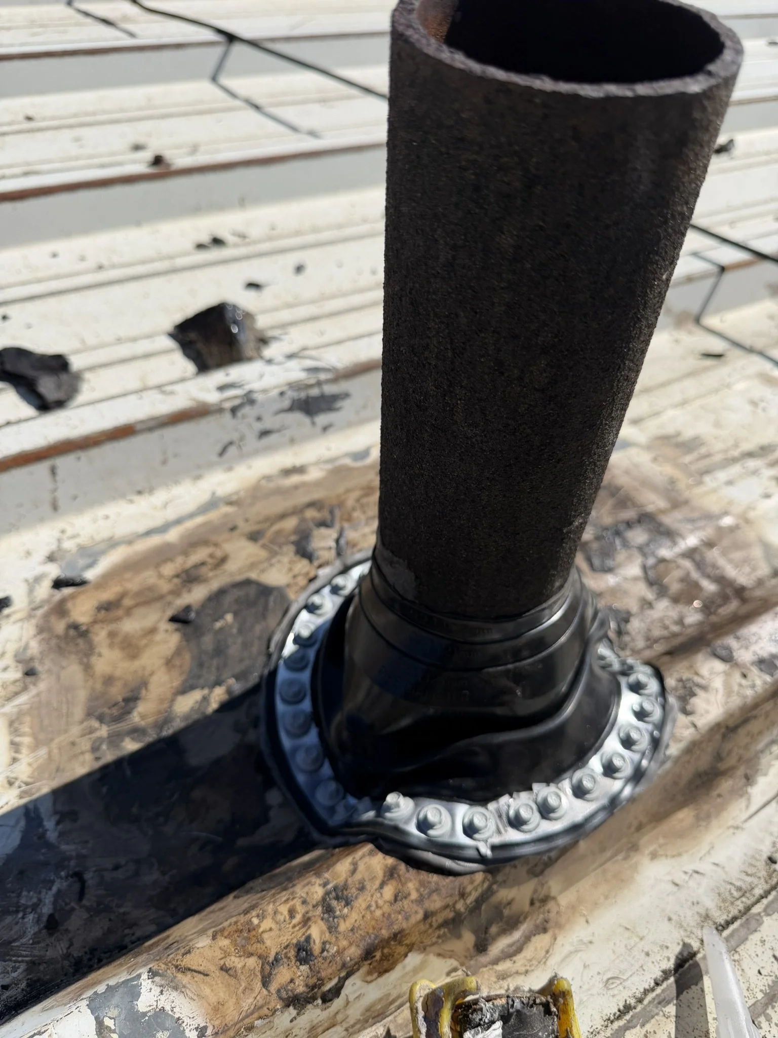 New black pipe boot with a screw-fastened base on the Englewood metal roof.
