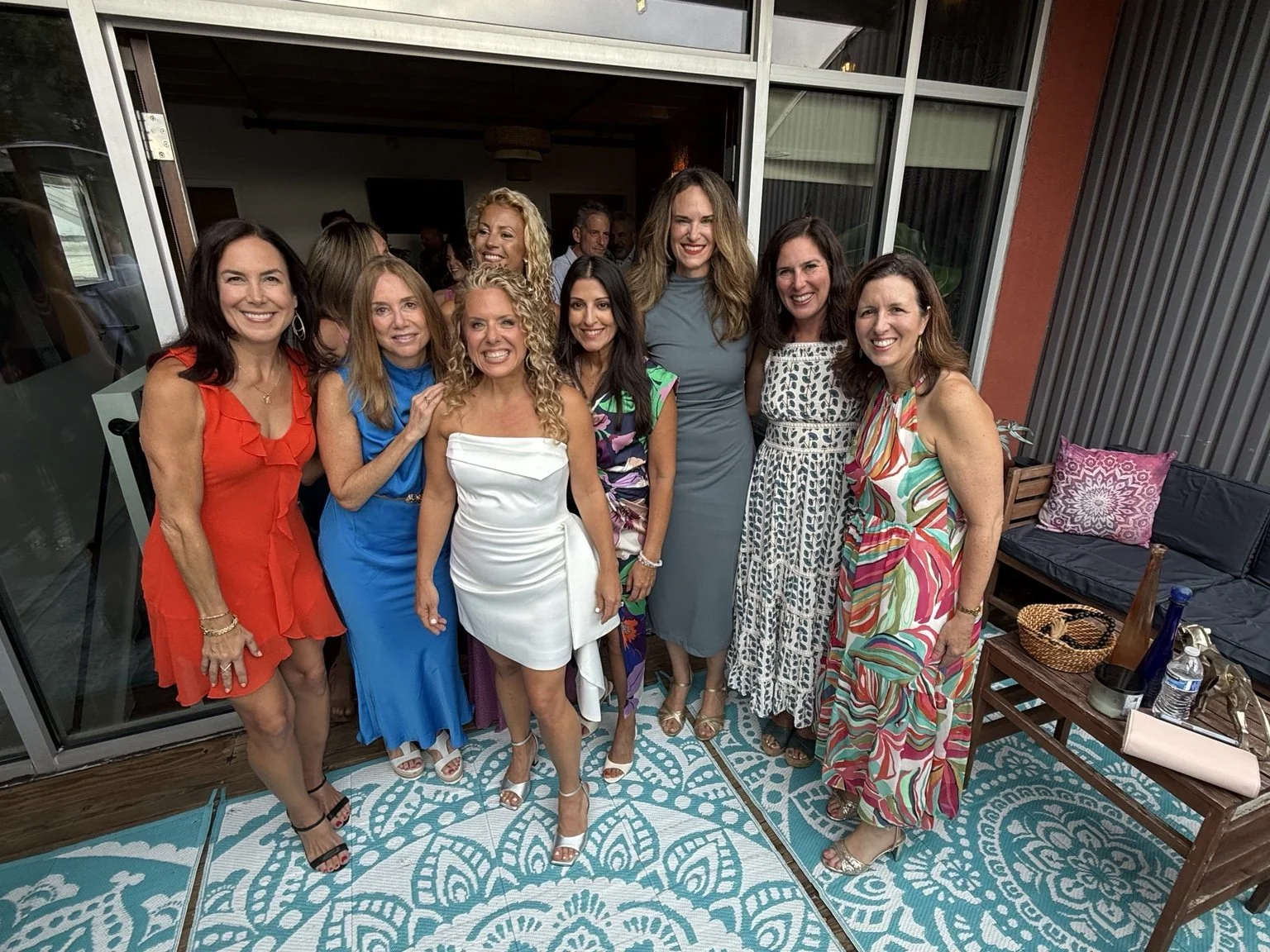 Women gathered together on the studio patio in daylight.
