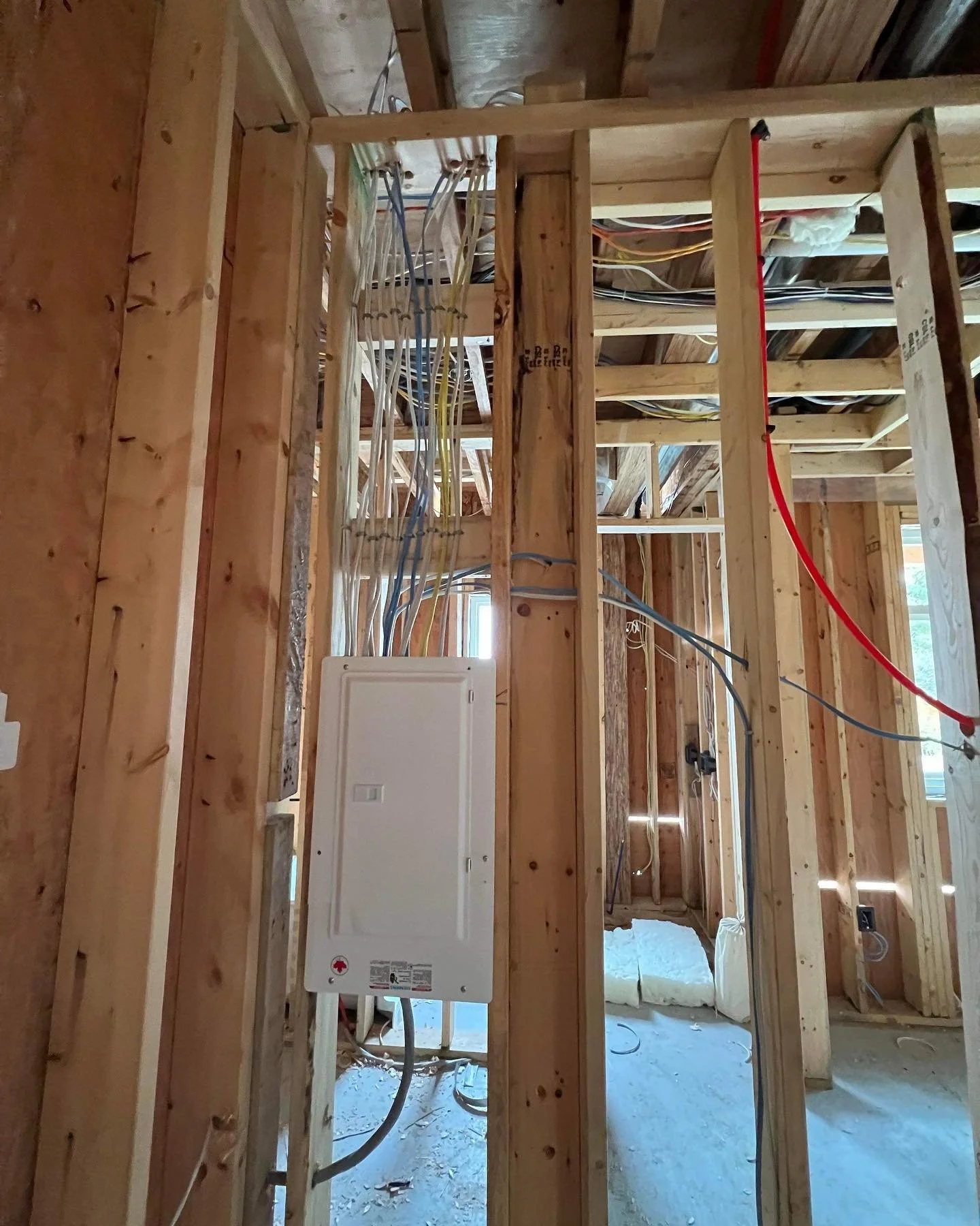 Electrician routing new wiring during a house rewiring project in the Lower Mainland.