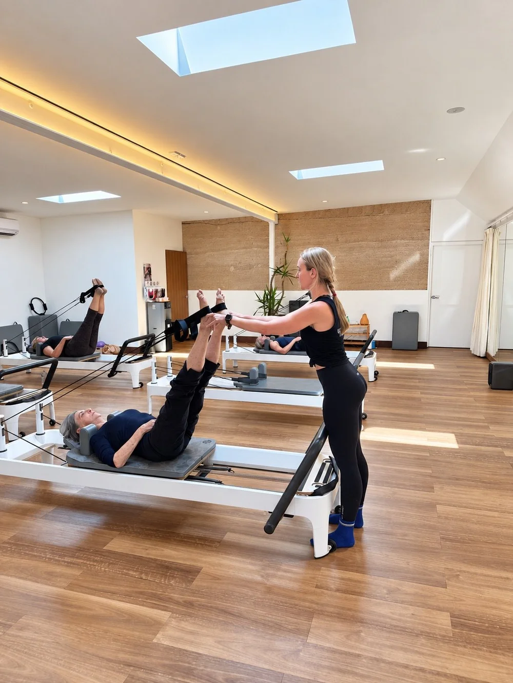 A BeLigned instructor guiding a client through a Reformer Pilates exercise in the Mullumbimby studio