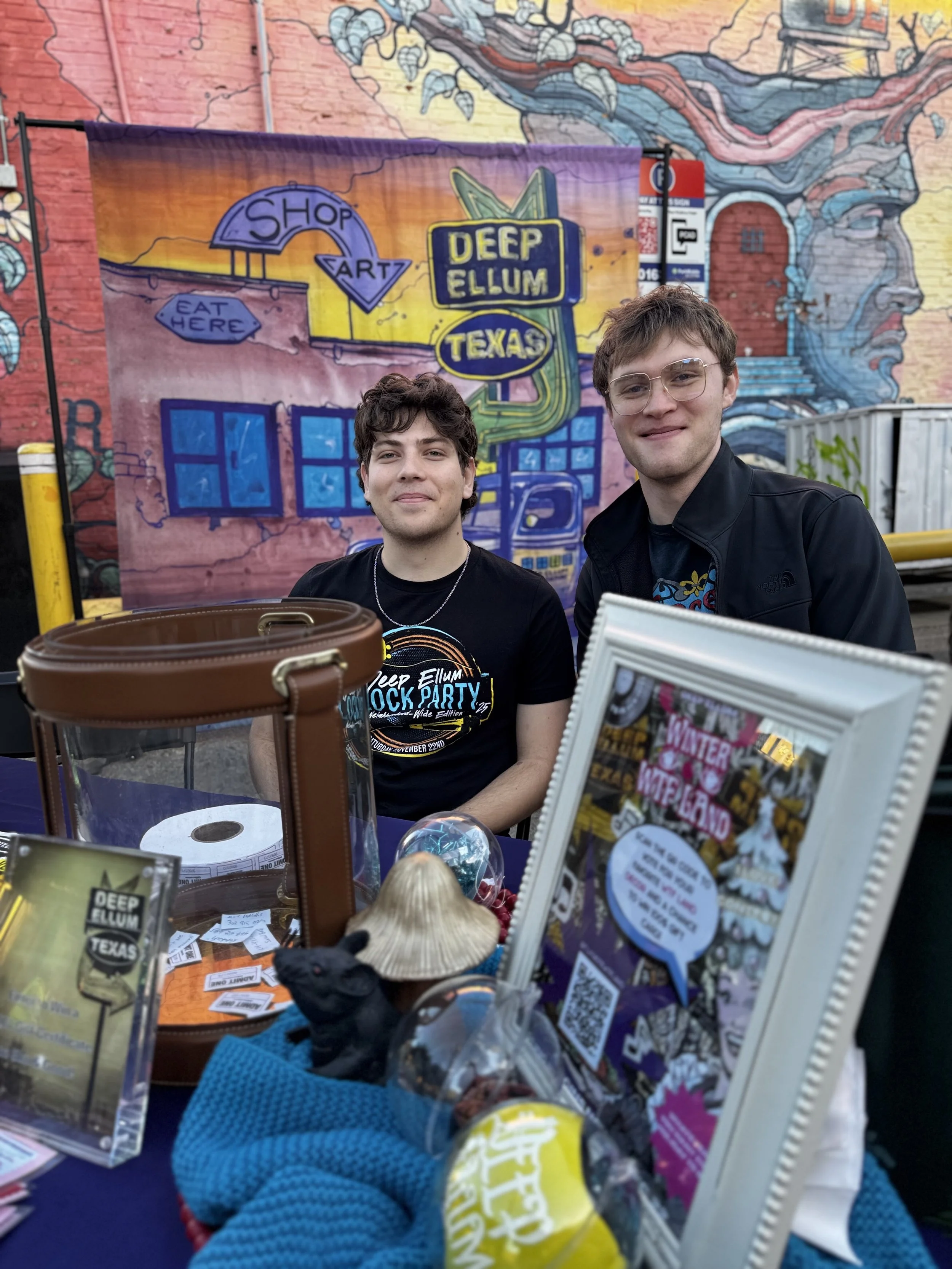 A Deep Ellum Foundation intern and volunteer at an information table during a neighborhood event.