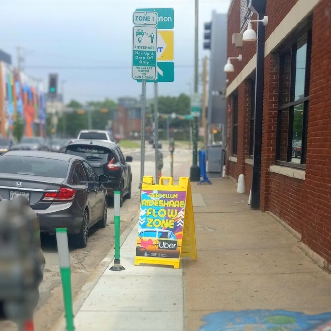Deep Ellum rideshare flow-zone signs marking a pickup and drop-off area.
