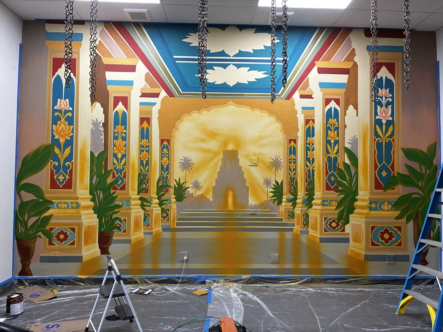 Temple mural in progress with painted columns, lotus patterns and flat color areas before final airbrush shading
