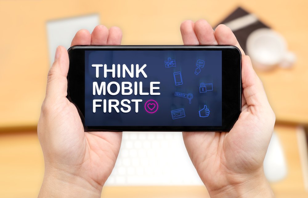 Picture of hands holding a mobile phone with 'THINK MOBILE FIRST' written on it